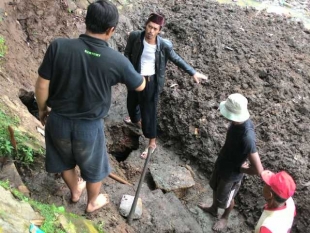 Sejumlah warga sedang menutup lubang besar di Situ Parigi