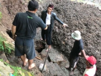 Sejumlah warga sedang menutup lubang besar di Situ Parigi