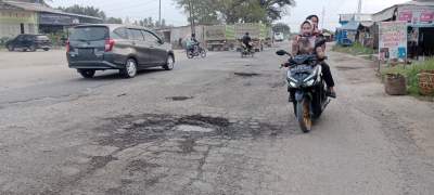 Pengguna jalan melintasi Jalan Access Road Inalum rusak parah.