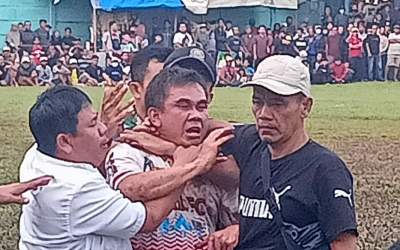 Edy Mamat jersey putih merah dibawa keluar lapangan oleh panitia turnamen sepakbola Pakujaya Cup 7.