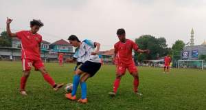 Pemain Putra Peninggilan (jersey putih) berusaha melewati hadangan dua pemain Nabil FC (jersey merah). Dalam pertandingan itu, Nabil FC asal Pagedangan, Kabupaten Tangerang, menang dengan skor akhir 5-2.