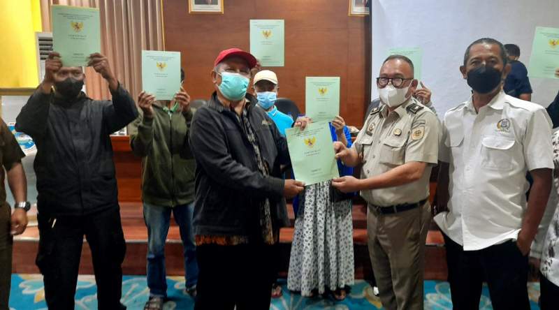 Anggota Komisi DPRD Tangsel dan BPN bersama Camat Pamulang membagikan sertifikat PTSL kepada masyarakat Pamulang.