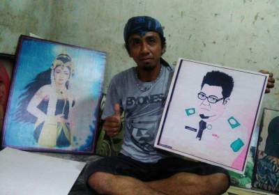 Chandra menunjukkan hasil lukisannya.