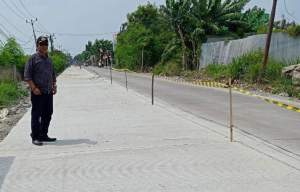 H. Dulatif, Kades Pasilian Kecamatan Kronjo, memantau proyek rehabilitasi jalan Pejamuran - Kronjo.