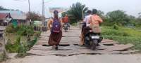 Anak sekolah melintasi jembatan Kayu Besar yang rusak parah.