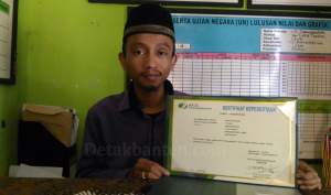 Kepala MTs Daaruttasihah Eva Nurohman menunjukkan sertifikat BPJS Ketenagakerjaan.