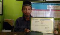 Kepala MTs Daaruttasihah Eva Nurohman menunjukkan sertifikat BPJS Ketenagakerjaan.