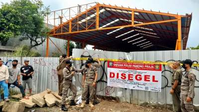 Petugas Pol PP Tangsel saat lakukan penyegelan bangunan gudang tak ber-IMB di Jalan Raya Siliwangi, Pamulang.