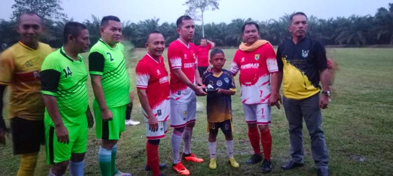 Bupati Serdang Bedagai, Darma Wijaya didampingi Manager PTPN III Silau Dunia, Kasiman Saragih menyerahkan sepatu bola kepada pelajar.