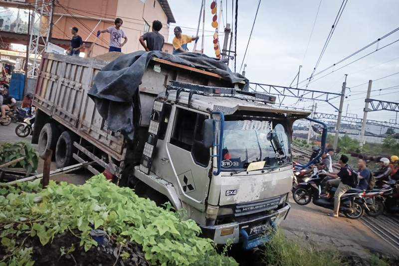 FOTO: Truk Muatan Pasir Terperosok ke Parit di Palang Pintu Perlintasan Rel Stasiun Serpong
