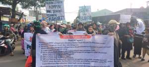 Warga Setu bentangkan spanduk penolakan penutupan jalan oleh BRIN.