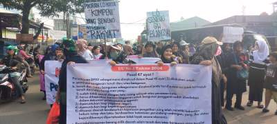 Warga Setu bentangkan spanduk penolakan penutupan jalan oleh BRIN.