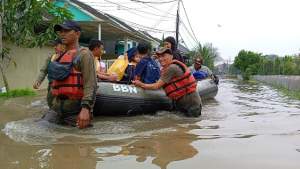 Petugas Pol PP Tangsel saat mengevakuasi warga terdampak banjir di Puri Bintaro Hijau, Jombang, Ciputat.