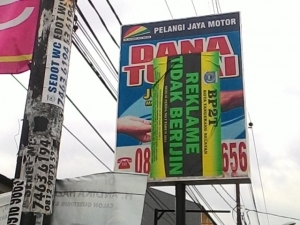 Salah satu reklame tak berijin di Jalan Jombang Raya yang di pasangi stiker oleh BP2T Tangsel