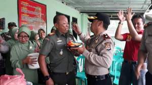 Kapolsek Tigaraksa Kompol Dodit menyuapi nasi tumpeng kepada Danramil Tigaraksa Kapten Bambang EP saat HUT TNI ke-72.
