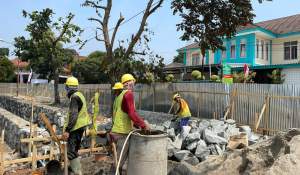 Sejumlah pekerja sedang memasang batu kali untuk pondasi salah satu bangunan penunjang Alun Alun Pondok Aren.