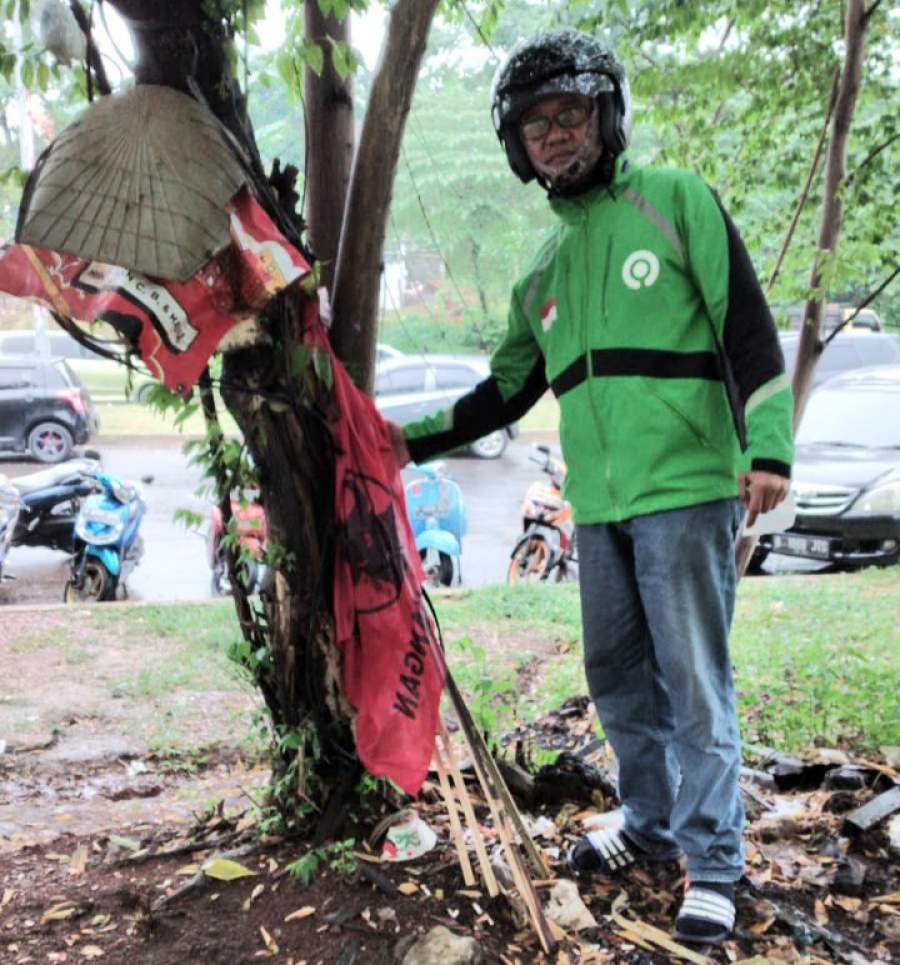 Taufiq (45) driver Ojol menemukan bendera PDIP berserakan tak jauh dari tempat pembakaran sampah depan Polres Tangerang Selatan di Lengkong Gudang, Kamis (2/7/2020) sore. 