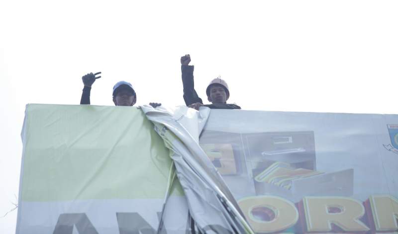 Petugas Pol PP Tangsel saat mencopot APK yang terpasang pada billboard di Jalan Raya Rawa Buntu, Serpong.