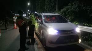 Petugas Polda Banten saat mengecek kendaraan terkait adanya larangan mudik di Gerbang Tol Merak, Kota Cilegon, Sabtu (25/4) malam. 