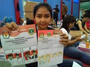 Salah satu relawan Pelipat surat suara tengah menunjukan surat suara yang rusak.