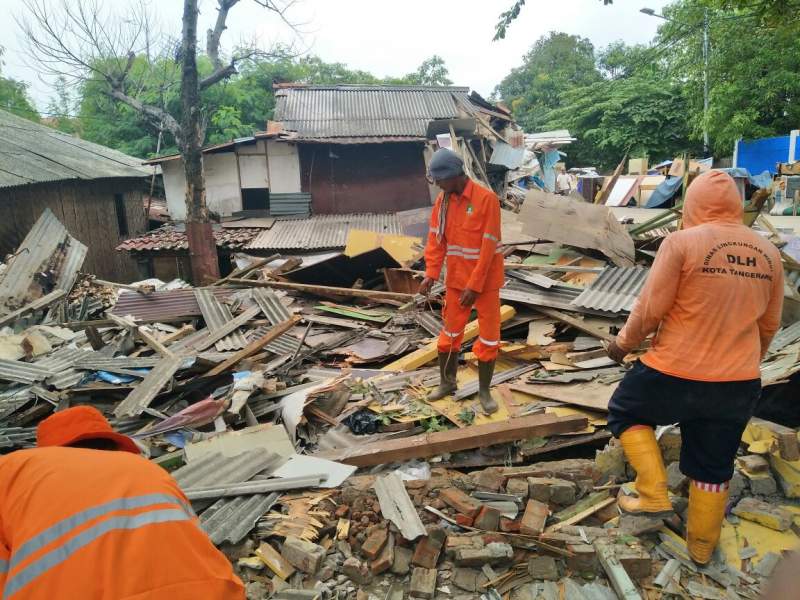 Petugas membersihkan puing pembongkaran bangli.
