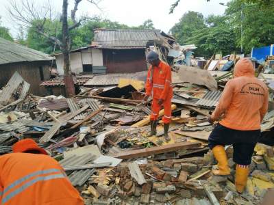 Petugas membersihkan puing pembongkaran bangli.