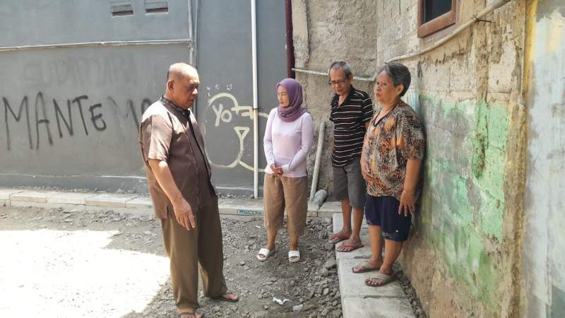 Ketua RW 09 Kelurahan Jombang, Rohman bersama warga meninjau perbaikan jalan dan drainase di RT 01 yang kerap dilanda banjir.