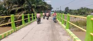 Warga melintasi jembatan penghubung Pematang Ganjang selesai dibangun