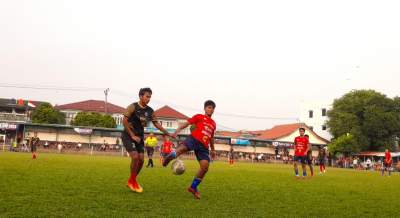 Pemain Ponser, Alam (jersey merah) hadang bola yang mengarah ke pemain Porba City, Jabrix (jersey hijau) dalam laga 32 besar Pakujaya Cup 8 di Stadion Mini Pakujaya, Serpong Utara.