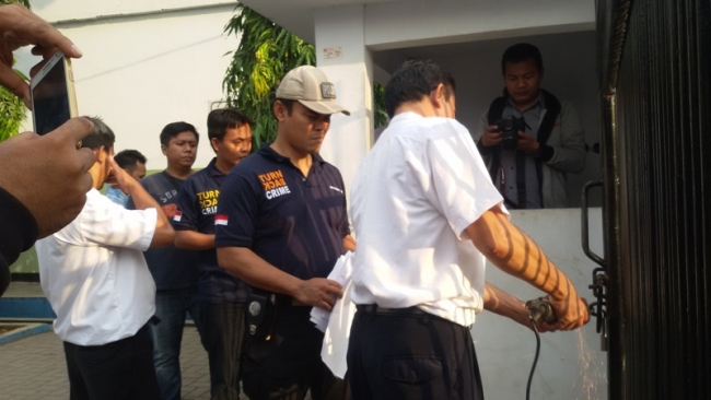 kepala sekolah (putih) bersama Kanit (Biru) sedang berupaya membuka pagar