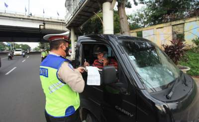 Ilustrasi polisi lalu lintas sedang menilang pengendara yang melanggar di ruas jalan.