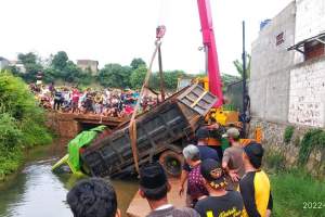 Evakuasi truk bermuatan batu yang terperosok ke kali di Jalan Telaga, Kedaung, Sawangan, Depok, Senin (21/2/2022). (Dok. Aldy Arjuna)