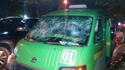 Satu unit angkot rusak akibat bentrok sopir angkot dengan ojek online.